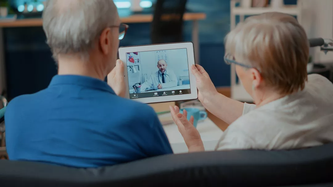 Future of Telemedicine. Senior couple attending online meeting with doctor on digital tablet, doing remote consultation at home. Elder people using videoconference call on modern gadget for internet telemedicine.